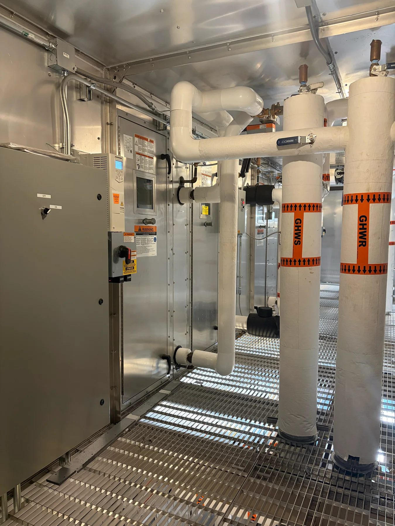 Commercial air-handling equipment and insulated hydronic piping at a ZMS work site